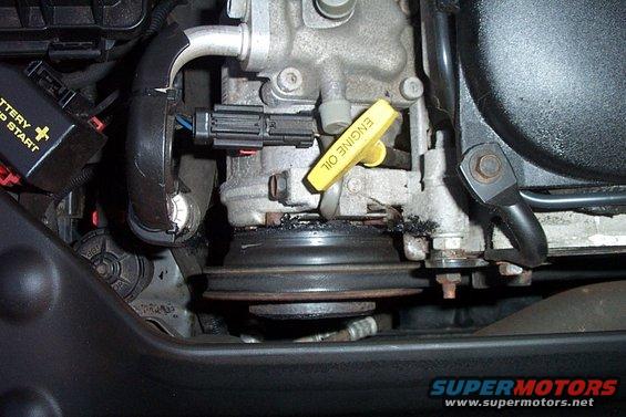 Yellow engine oil dipstick and pulley in engine bay