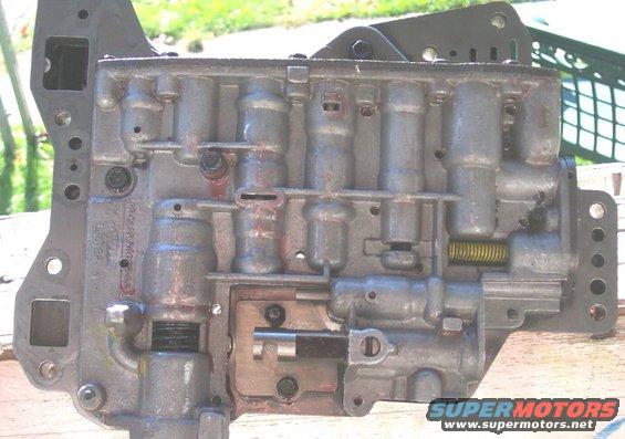 Close-up of an automatic transmission valve body with visible solenoids and springs