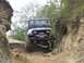1990 Ford Bronco - A black Jeep Wrangler navigates a challenging rocky off-road trail.