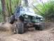 1990 Ford Bronco - This heavily modified SUV navigates a challenging off-road course with its large tires and custom roll cage.