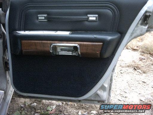 Interior door panel with wood trim and black carpet