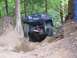 1990 Ford Bronco - Off-road vehicle tackling a challenging trail with significant elevation change.