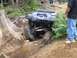 1990 Ford Bronco - This modified Jeep Wrangler navigates a challenging off-road obstacle course with large rocks and fallen trees.