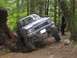 1990 Ford Bronco - A Toyota pickup truck navigates a steep, wooded trail with large tires.