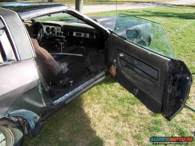 car interior with open door, showing dashboard, seats, and door panel
