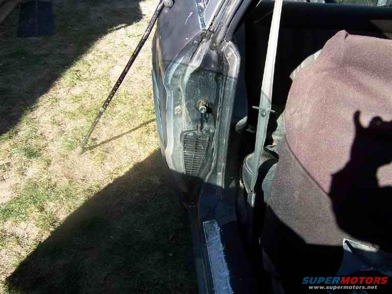 Car door open, showing interior seat and seatbelt. A prop rod is holding the door open