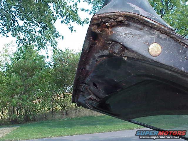 Rusted car door frame with a circular emblem