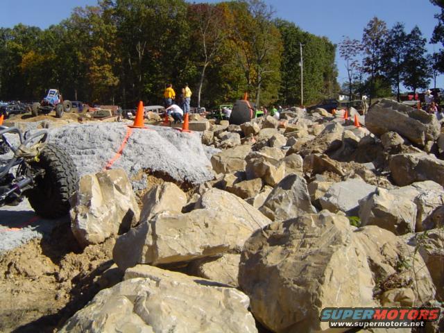 Off-road vehicles on rocky terrain with orange cones marking a course