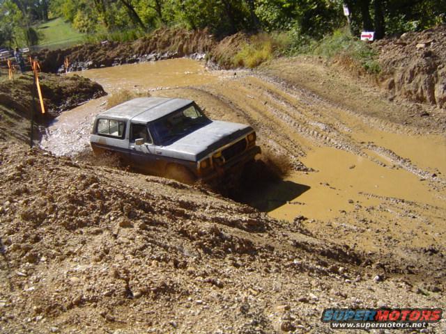 Gray 1979 Ford Bronco navigating a muddy obstacle course