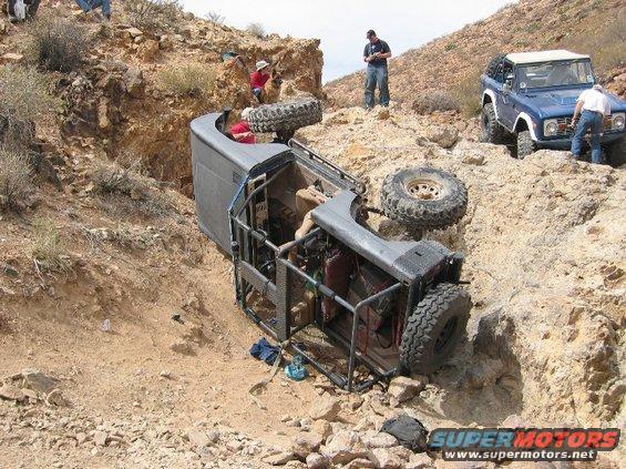 Overturned 1972 Ford Bronco in a ditch with another Bronco nearby