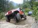 1990 Ford Bronco - Two Jeeps tackle a challenging off-road course on a wooded mountain trail.