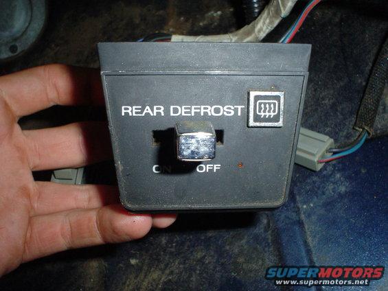 Black rear defrost switch with silver toggle, labeled 'REAR DEFROST'