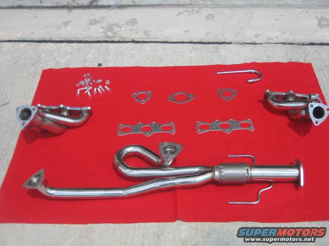 Exhaust headers and pipes laid out on a red cloth