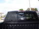 2004 Ford F-150 - Rear view of a pickup truck's tinted window, displaying various stickers and a reflection of the surroundings.