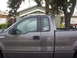 2004 Ford F-150 - Side view of a gray Ford F-150 pickup truck parked in a residential area.