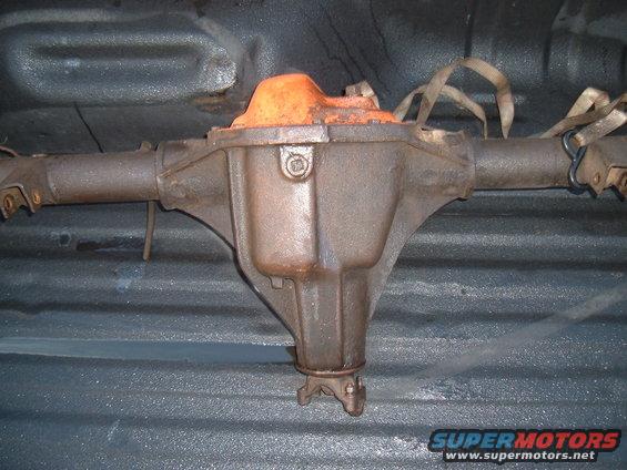 Rear differential assembly with orange cover, strapped down in a truck bed