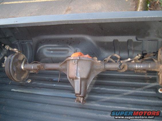 Rear axle assembly with drum brakes, strapped in a truck bed