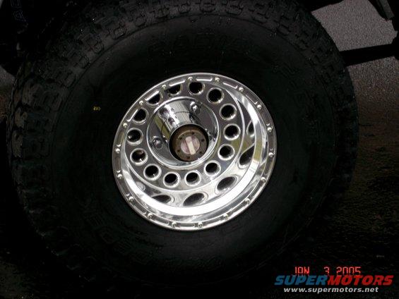 Chrome wheel with holes and large tire, date stamp 2005
