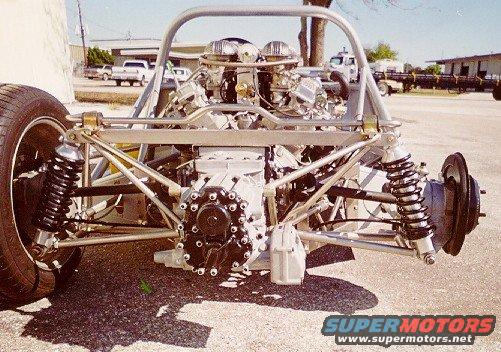 rear suspension and V8 engine of a custom-built car, exposed frame and roll cage visible