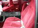 1994 Ford Bronco - The interior of a 1992 Ford Bronco shows red velour seats and debris scattered on the floor and console.