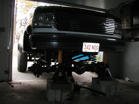 1992 Ford Bronco front end lifted on jack stands, showing suspension components