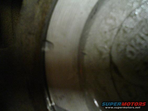 Close-up of a metal engine component with some texture and markings
