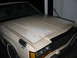 1985 Ford Crown Victoria LTD - The front of a beige Ford Crown Victoria is shown, with visible damage and repair marks on the hood and fender.