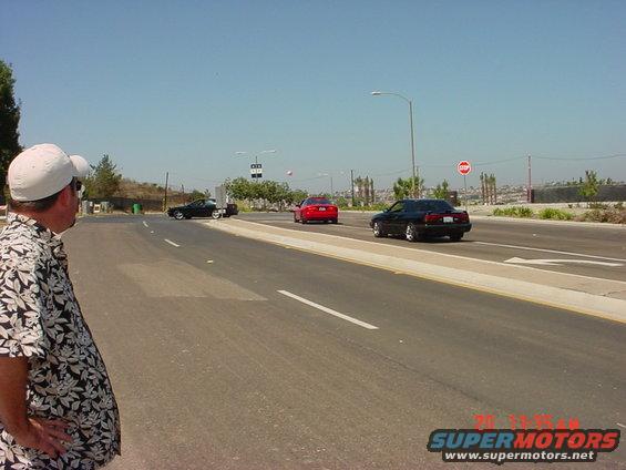 Black coupe, red coupe, and black sedan on a sunny day
