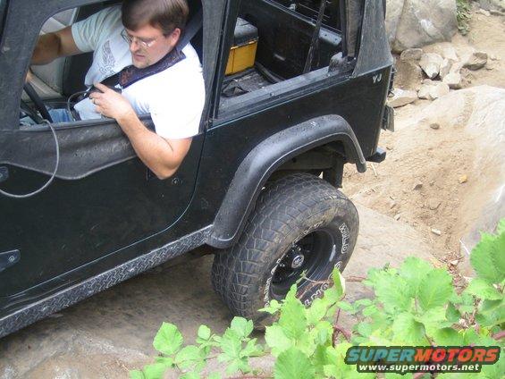Black Jeep Wrangler YJ side view on rocky terrain