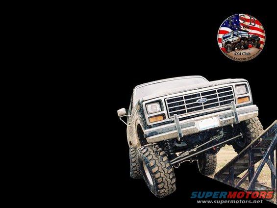 Lifted Ford truck on a ramp. Has a '4x4 Club' sticker with American flag