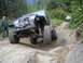 1990 Ford Bronco - A modified Jeep Wrangler tackles a challenging off-road course, with another vehicle in the distance.