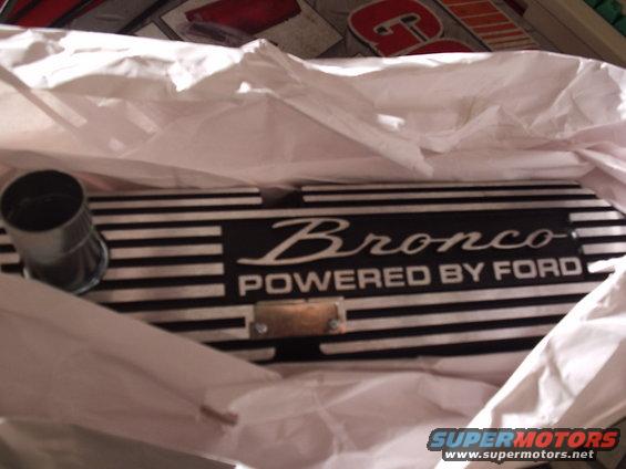 Black valve cover with white stripes and 'Bronco POWERED BY FORD' text