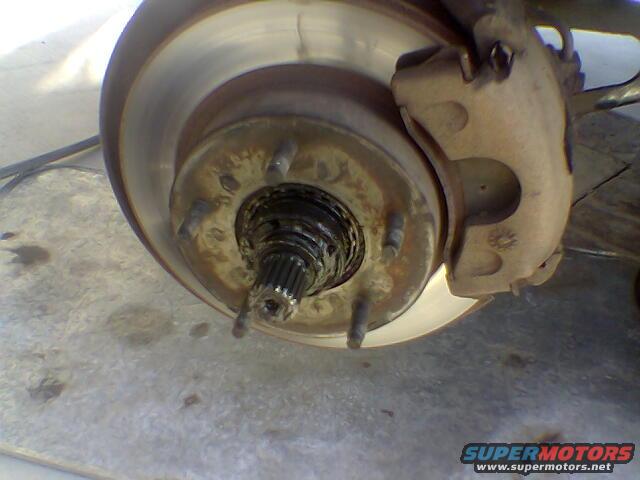 close-up of a vehicle's front wheel hub assembly with brake rotor and caliper