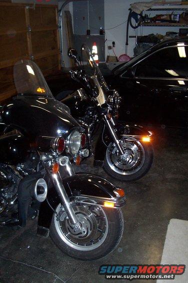 Front view of two black Harley-Davidson motorcycles parked in a garage