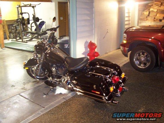Black Harley-Davidson touring motorcycle parked indoors, rear view