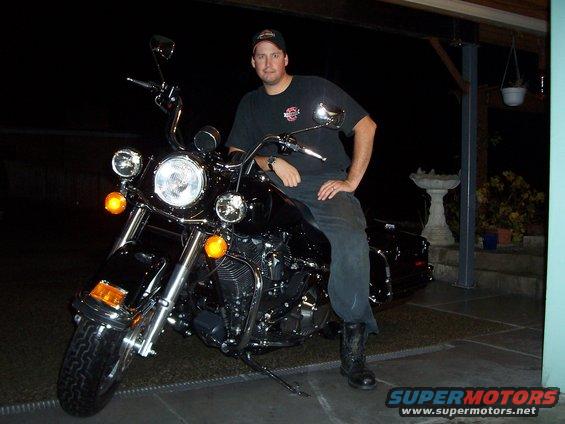 Man sitting on a black 2005 Harley-Davidson FLH motorcycle