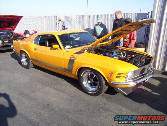 Yellow 1970 Ford Mustang Boss 302 with hood open, parked outdoors
