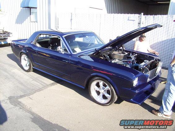 Dark blue 1965 Ford Mustang coupe with hood open, showing engine
