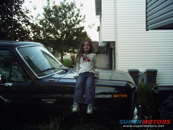 Black Ford Bronco with a girl sitting on the hood