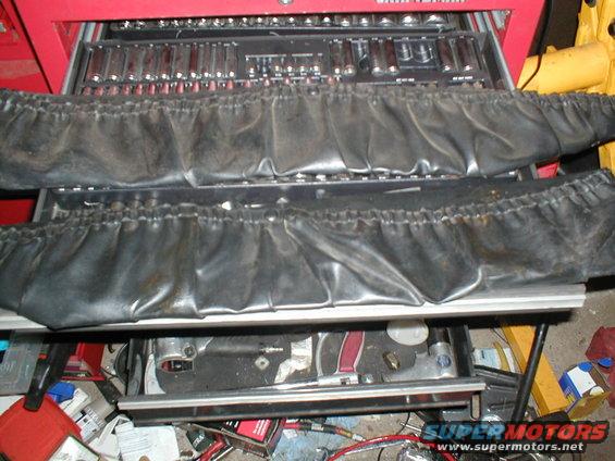 Red tool chest with two rows of black vinyl covers over sockets and tools