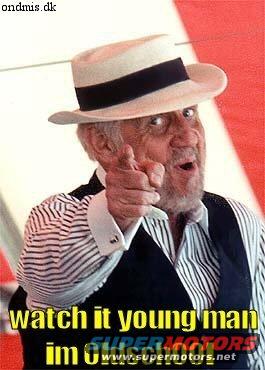 Man in fedora pointing and speaking, with text overlay