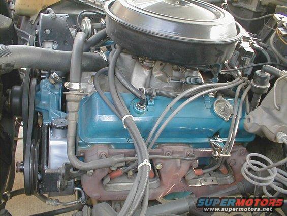 Close-up of a V8 engine with blue valve covers and a black air cleaner