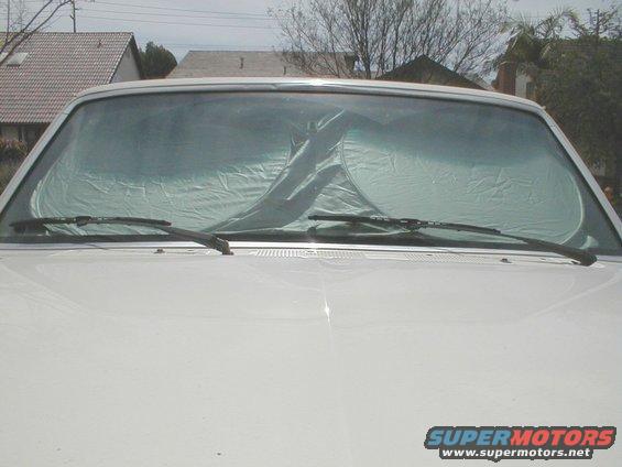 front of white pickup truck with sunshade on windshield