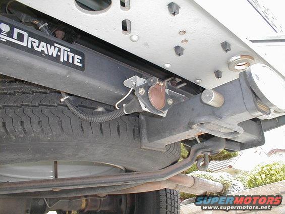 Underside of a truck showing a Draw-Tite trailer hitch receiver, spare tire, and exhaust pipe