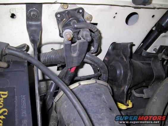 Engine ignition coil and wiring with visible text on battery