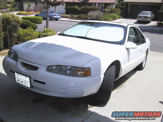 White coupe with sunshade in windshield, parked in driveway. License plate 3HSH327