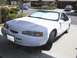 1997 Ford Thunderbird - A white coupe is parked in a suburban driveway, with another car visible in the background.