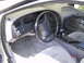 1997 Ford Thunderbird - The interior of a 1997 Ford Thunderbird is captured from the passenger side, revealing the dashboard and seating.