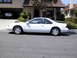 1997 Ford Thunderbird - Side view of a white 1997 Ford Thunderbird parked on a residential street.