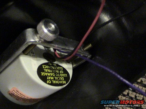 Close-up of an electronic component with wires and warning labels